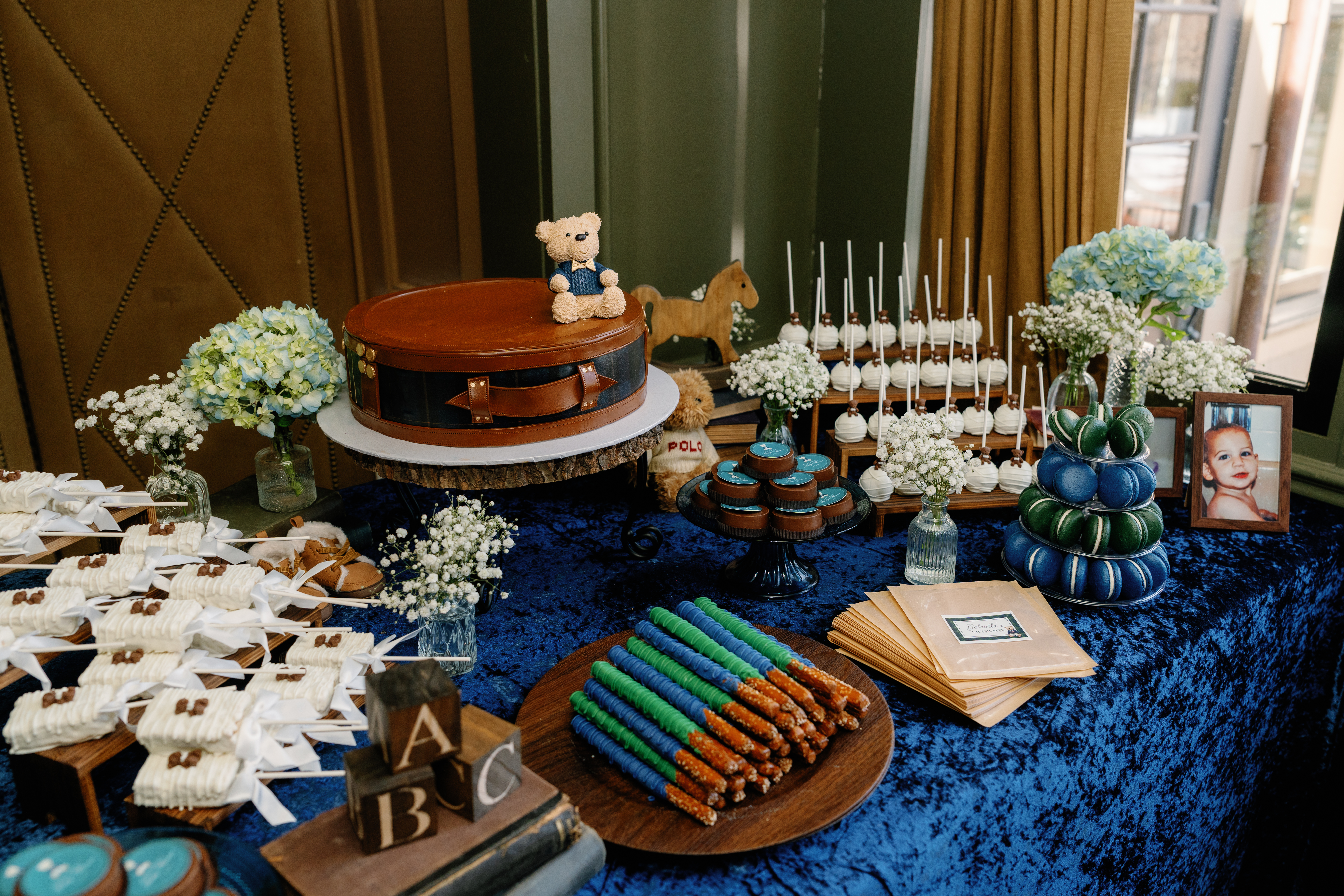 Baby shower dessert table with teddy bear cake and hand-decorated cookies