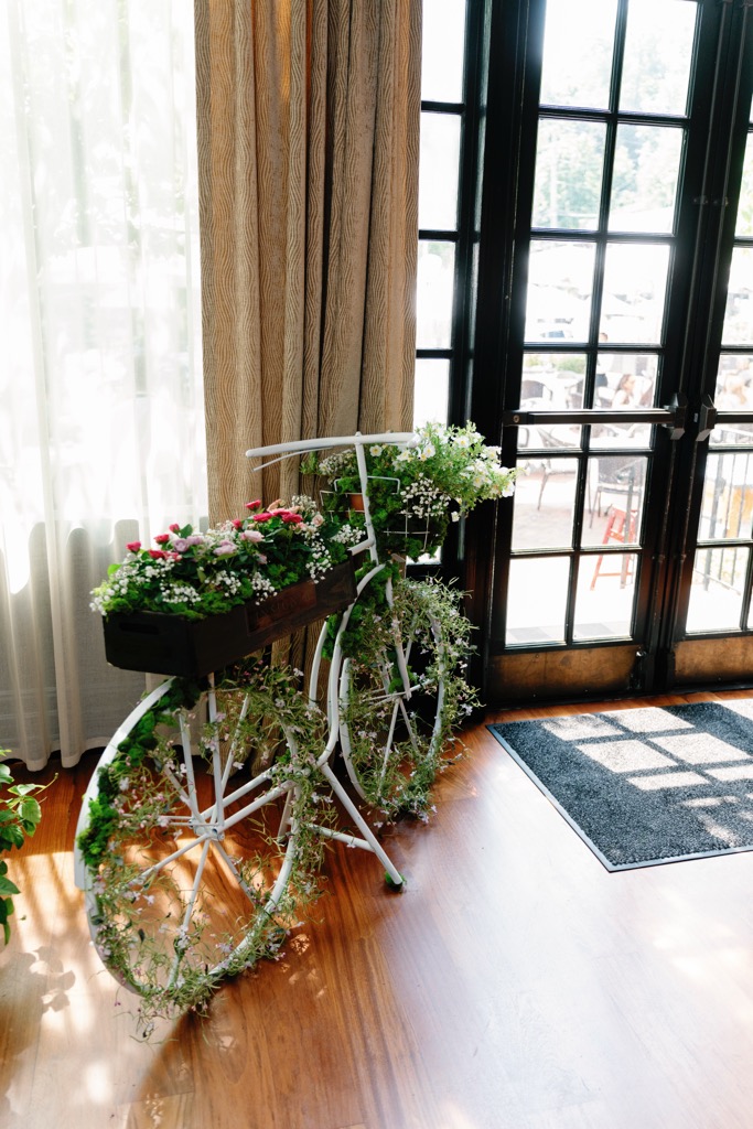 Vintage bicycle decorated with fresh flowers and greenery as outdoor event decor